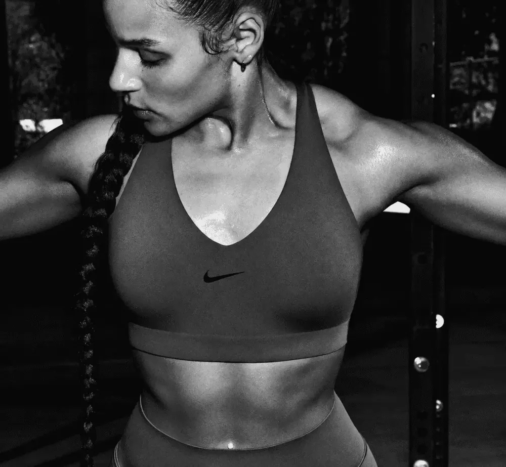 A runner training on an outdoor track wearing a Nike sports bra