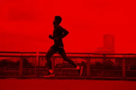 A runner crossing a bridge at dusk