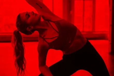 A woman stretching in a red-lit room
