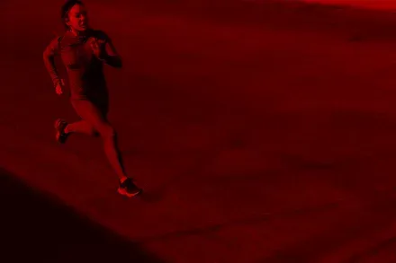 A runner on a red-lit path