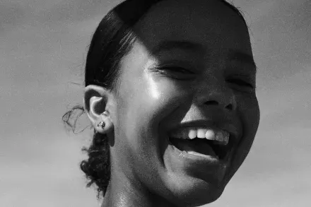 A smiling runner wearing earbuds
