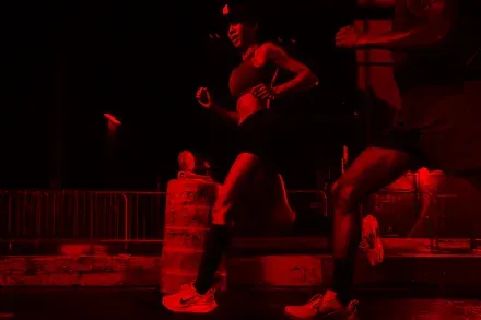 Runners mid-stride under red light